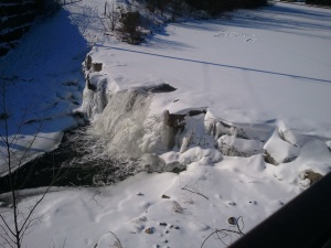 Waterfall in the park I walk through.  The front is frozen and the water falling behind the ice.